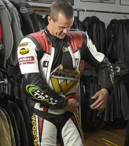 Eric Wood demonstrates Vanson's dual zippered front panel on his Air-Pro air bag racing suit